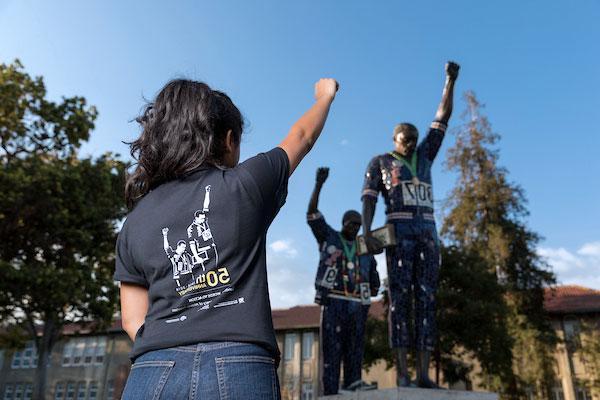 A student with their closed fist in the air.